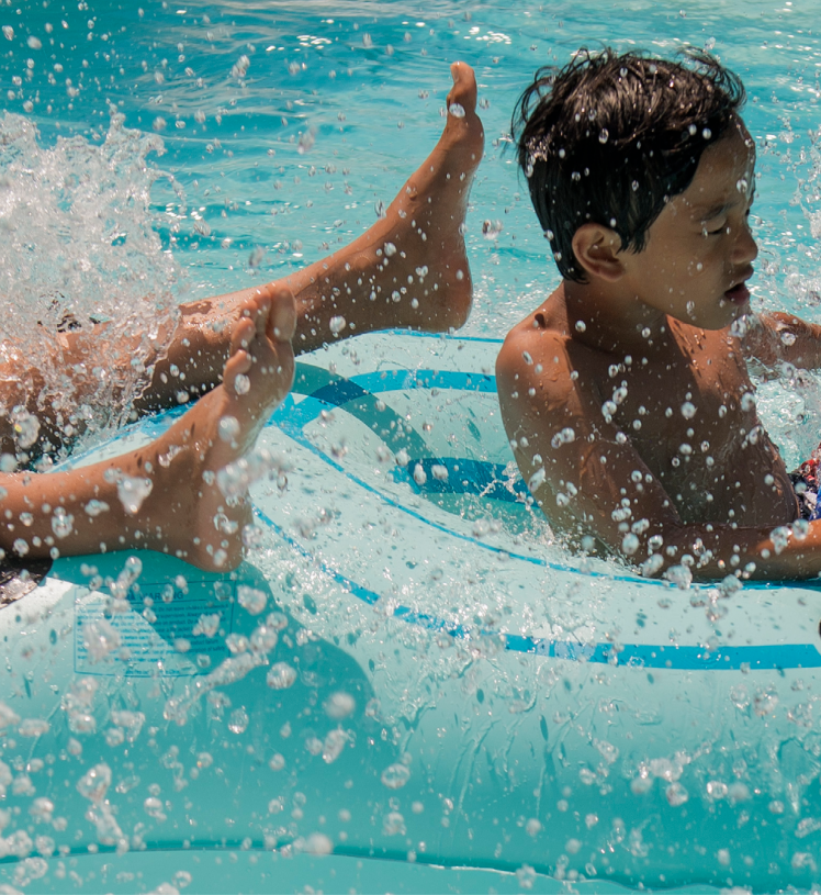 Two children floating on inner-tubes in water