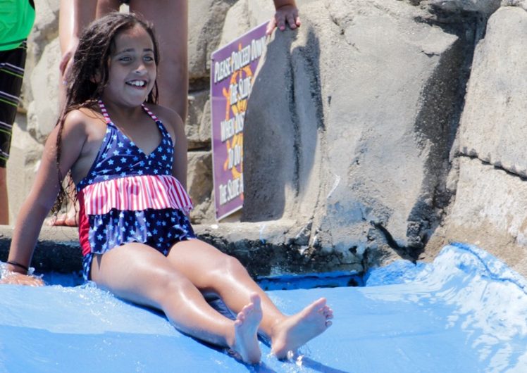 Girl smiling at top of water slide